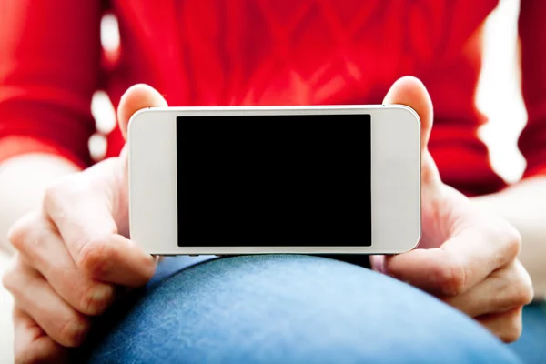 Kız bir akıllı telefon elinde tutar.