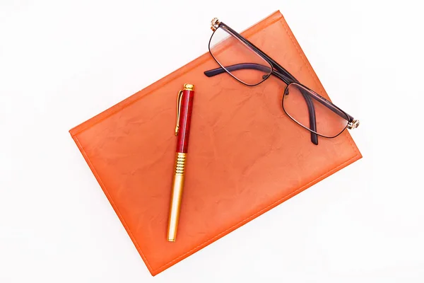Flat lay foto de bloco de notas, caneta e óculos isolados no branco — Fotografia de Stock