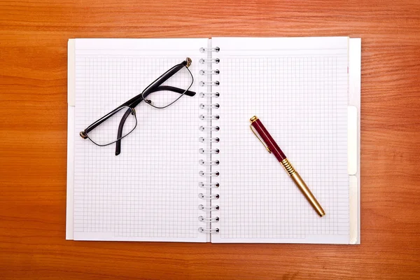 Foto plana de bloc de notas, bolígrafo y gafas aisladas en el blanco —  Fotos de Stock