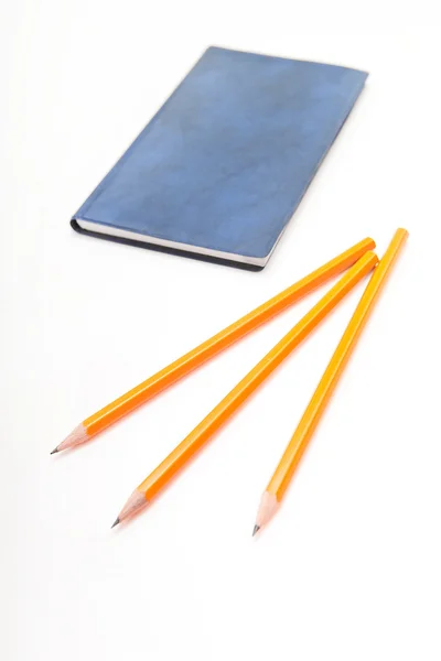 Mavi defter ve beyaz zemin üzerine sarı kalemler