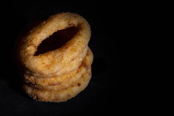 Onion rings isolated on the black background. Top view