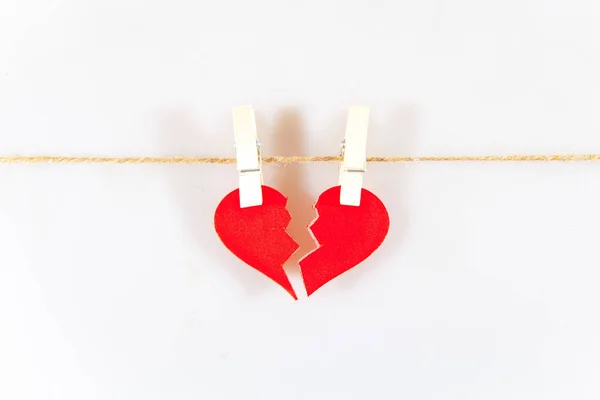 İki mandalda kırık bir kalp. Başarısız aşk. Beyaz arkaplan