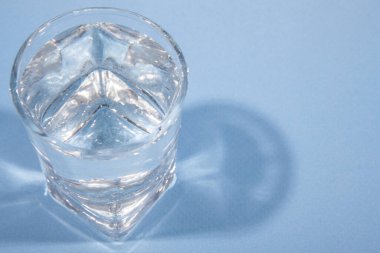 Alkolik içki. Muhtemelen votka. Mavi arka plan. Yakın plan.