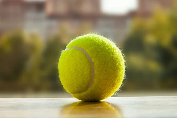 Tennis ball and sunshine. Small yellow ball. View from the window