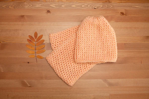 örme atkı ve şapka ahşap bir masa üzerinde