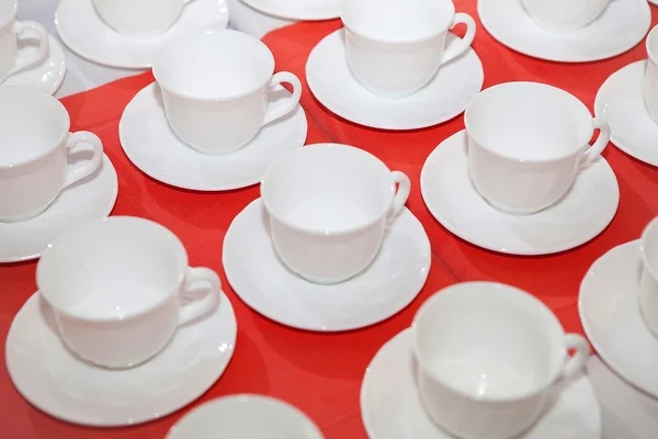 Xícara de chá branco em uma toalha de mesa vermelha — Fotografia de Stock
