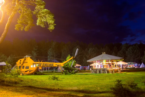 Tendas e helicóptero no acampamento turístico em uma clareira florestal, em t — Fotografia de Stock