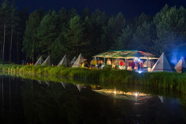 Festa noturna sob a tenda no lago — Fotografia de Stock