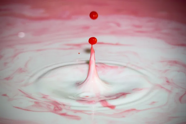 Splash of milk drop in pink color. — ストック写真