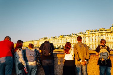 Saint Petersburg, Rusya - 17 Ağustos 2019: Saray Köprüsü 'nde turistlerle Kış Sarayı Hermitage Müzesi' nin Günbatımı