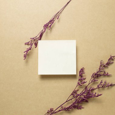 Kahverengi kraft kağıdında pembe sisli, kuru çiçekler olan boş bir not kağıdı. Üst görünüm, boşluk kopyala