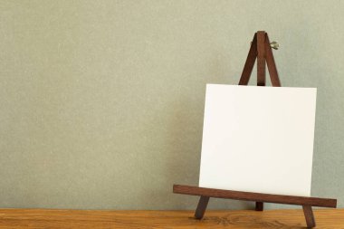 Tahta masa üzerinde boş tuval ile Easel. Haki yeşil arkaplan