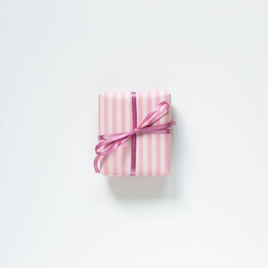 Beyaz arkaplanda pembe çizgili hediye kutusu var. Üst görünüm, boşluk kopyala