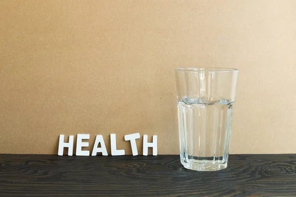 Glass with water on wooden table. brown background. Healthy food, Weight management