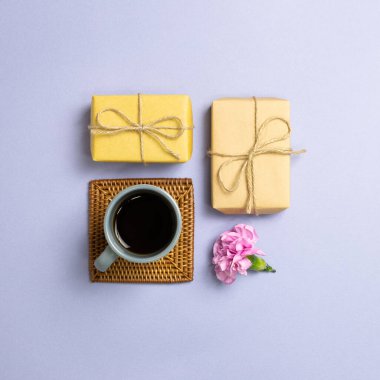 Hediye kutuları, bir fincan kahve, mor arka planda çiçek. Yıldönümü. düz alan, üst görünüm, kopyala boşluk