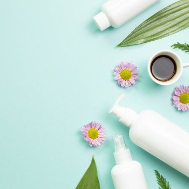 Mavi arka planda beyaz banyo şişeleri. Düz konum, üst görünüm, kopyalama alanı. Cilt bakımı ve kaplıca kavramı