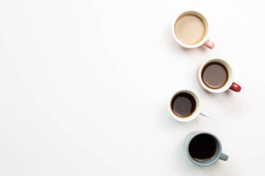 Beyaz arka planda çeşitli kahve fincanları. Üst görünüm, boşluk kopyala