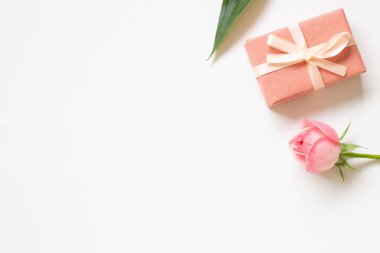 Beyaz arka planda hediye kutusu ve gül çiçeği. düz alan, üst görünüm, kopyala boşluk