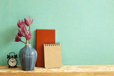 Defter, saat, tahta masadaki çiçek. yeşil arka plan. Çalışma ve öğrenim yeri