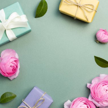 Yeşil arka planda çiçek ve yaprak olan hediye kutuları. düz alan, üst görünüm, kopyala boşluk