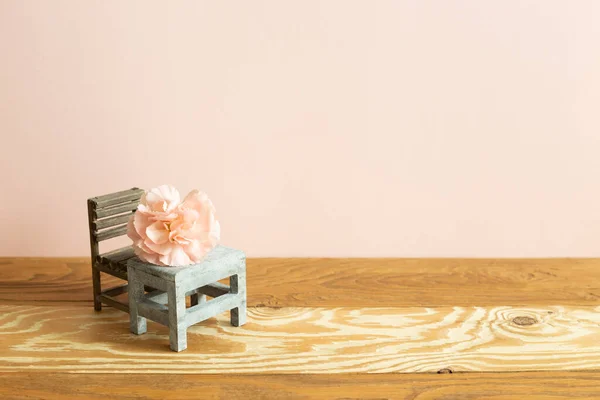 Pink carnation flower on school desk with empty chair