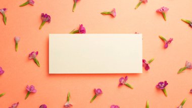 Turuncu arka planda pembe çiçek desenli not defteri. düz alan, üst görünüm, kopyala boşluk