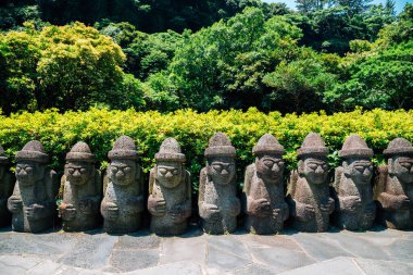 Dol hareubang taşı büyükbaba heykeli Jeju Adası, Kore 'deki Cheonjiyeon Şelalesinde.