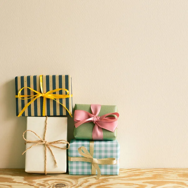 Stapel Geschenkdozen Houten Tafel Beige Muur Achtergrond — Stockfoto