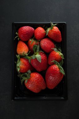 Plastik ambalajda taze olgun kırmızı bahçe çilekleri. Sağlıklı yaz meyveleri. Sağlıklı yaşam tarzı kavramı