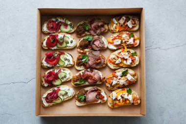 Parti ya da şenlik masası için farklı atıştırmalıklar. Domatesli Ciabatta sandviçi, jamon, krem peynir, sebze, ocak ve zeytin. Lezzetli şarap atıştırmalıkları