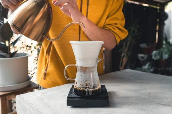 Drip coffee, barista pouring water on coffee ground with filter,brewing coffee