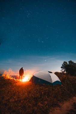 Geceleri kamp çadırları ve şenlik ateşleri.