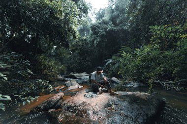 Şenlik ateşi, tropikal yağmur ormanlarındaki bir şelalenin yanında.,