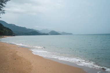 Yağmurlu bir günde adanın kumsalında deniz dalgaları