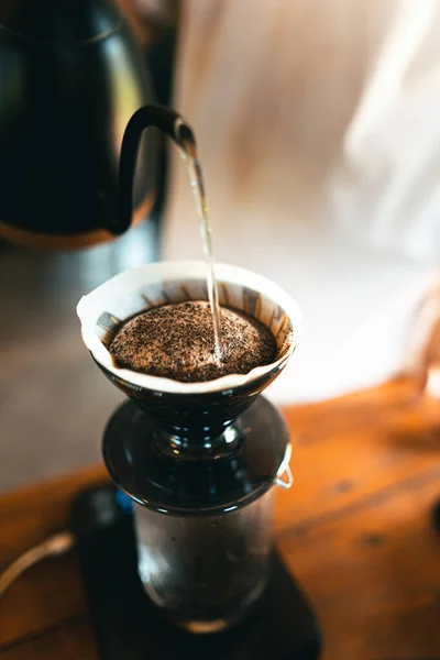 Drip coffee, barista pouring water on coffee ground with filter,brewing coffee