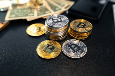 Bitcoin paraları ve para siyah bir iş masasında.
