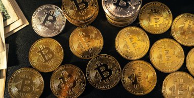 Bitcoin paraları arka planda siyah bir arkaplanda sıralanır
