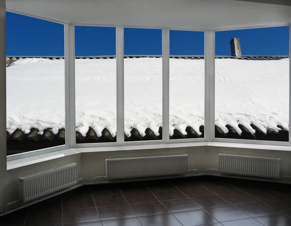 Ferestre cu vedere la acoperișul rural acoperit cu zăpadă — Fotografie, imagine de stoc