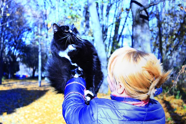 Femme avec chat noir dans le parc d'automne — Photo