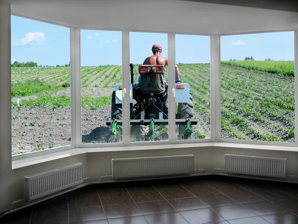 Plastic windows overlooking the peasant on the tractor — Stock Photo, Image