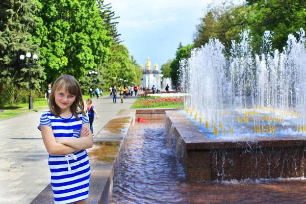 Modernes junges Mädchen erholt sich im Stadtpark mit Springbrunnen — Stockfoto