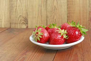 kahverengi beyaz tabakta olgun kırmızı çilek