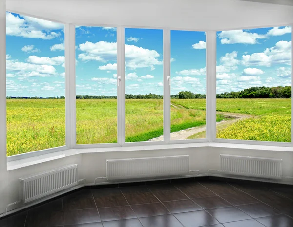 Window overlooking the summer field and country road Royalty Free Stock Photos