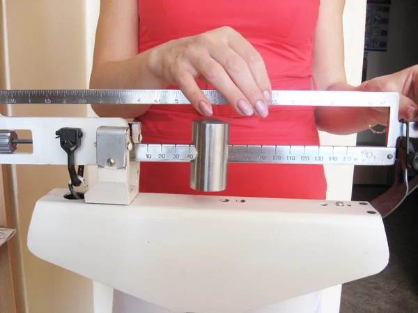 Mulher pesa nas balanças — Fotografia de Stock