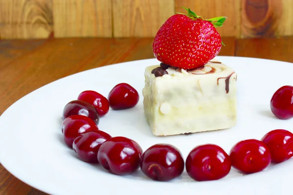 Erdbeeren und Kirschen auf dem Teller und Kuchen — Stockfoto
