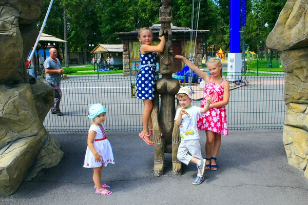 Dzieci bawią się w pobliżu Fantastyczny drewniana statua — Zdjęcie stockowe