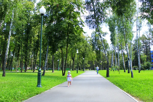 Baby walks alone on the footpath in the city park — стоковое фото