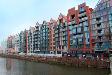 Gdansk / Polonya. 21 Haziran 2019: Gdansk 'ta su kanalının üzerinde duran binaların güzel mimarisi. Gdansk 'ta toprak seti. Şehirdeki bir su kanalı üzerinde modern evler. Polonya şehrinde turistler