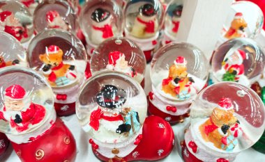 Cam toplardaki Noel Baba 'lar mağazada satılıyor. Noel Baba 'yla Noel cam kartopu. Noel için sembolik bir hediye. Noel cam küresi. Yeni yıl havası. Karlı oyuncak top ve Noel Baba