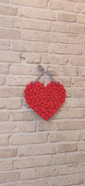 赤の心レンガの壁にかかっている 愛の文字が刻まれています 軽いレンガの壁に2つの手作りの心 コピースペース バレンタインデーへの贈り物 2つの形の心は古いレンガの壁にかかっている 恋人のシンボル — ストック写真